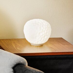 Lampe à poser Artemide Meteorite en verre texturé, posée sur une console