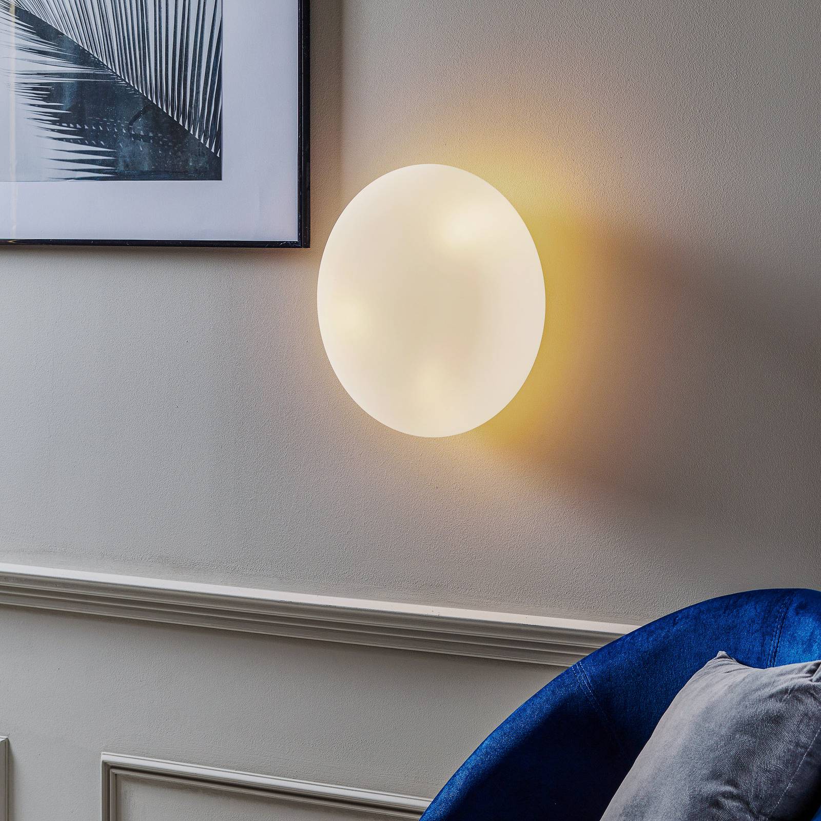 Applique Artemide Itka ronde en verre soufflé, posée sur un mur clair