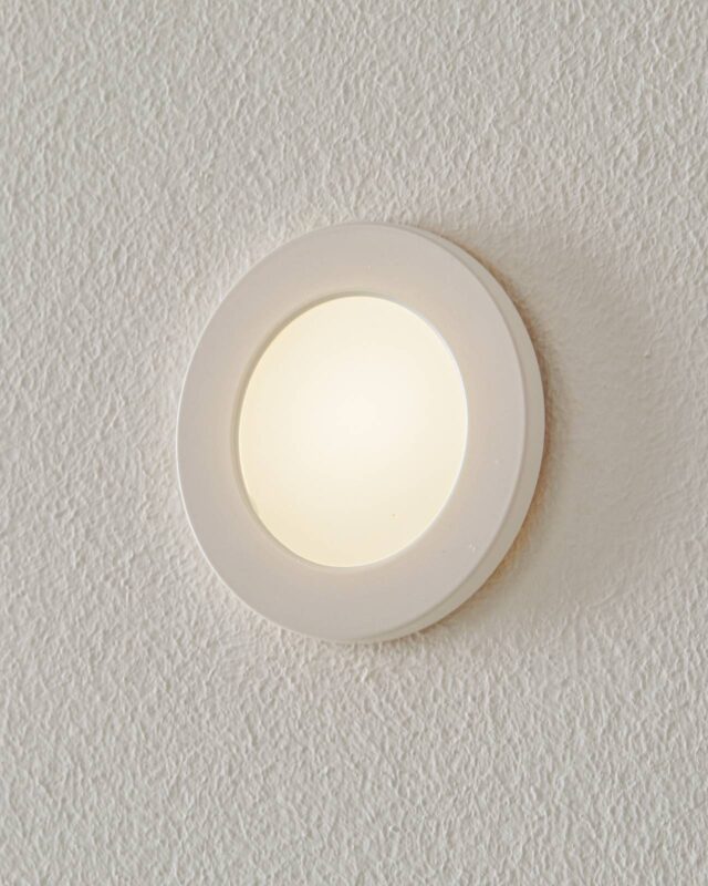 Une applique BEGA Accenta ronde encastrée avec cadre blanc et verre blanc